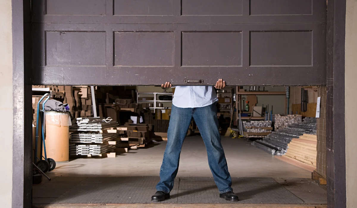 A man was opening the garage door in a storage room