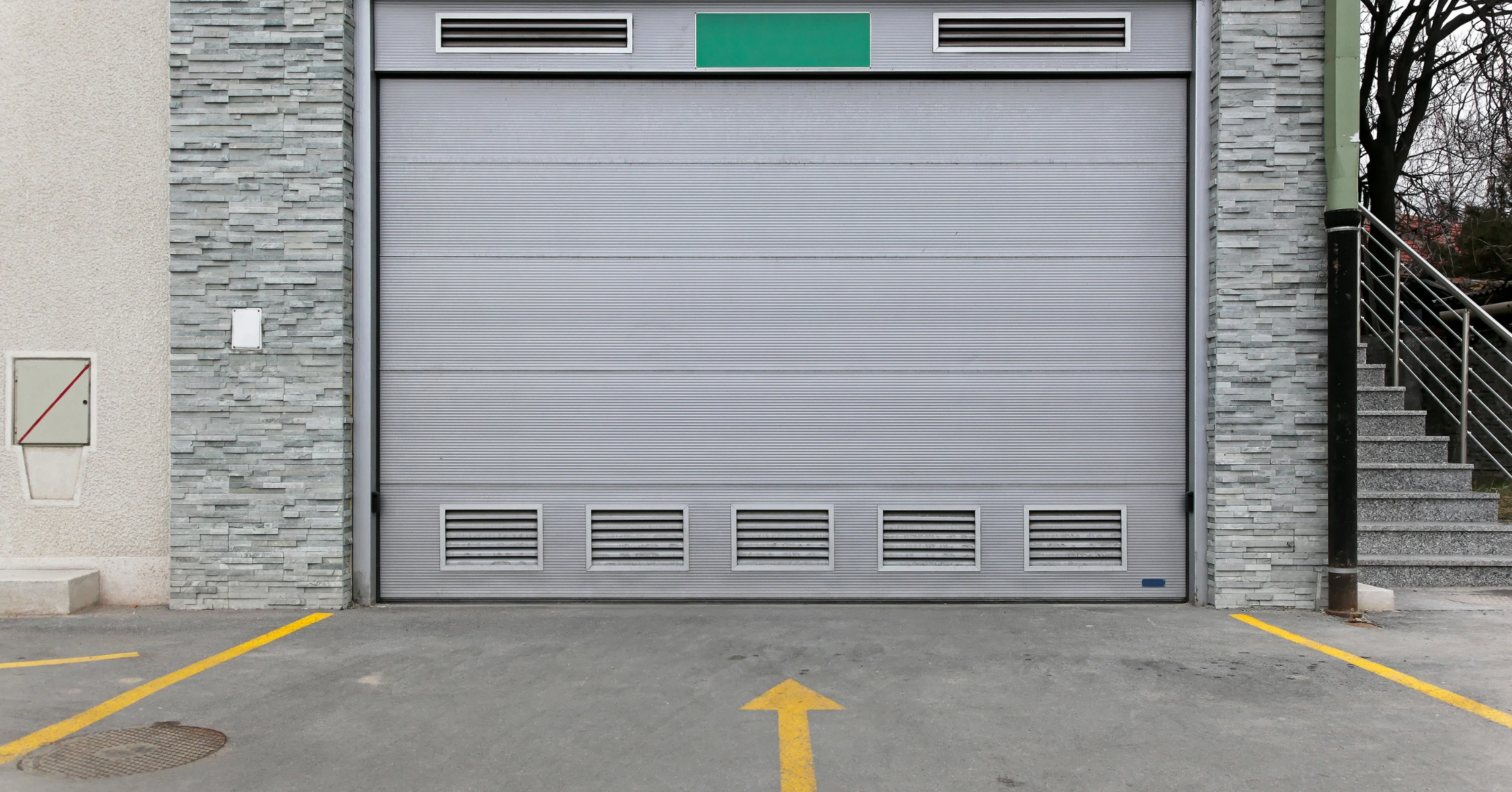 Gray garage doors and stairs on the side