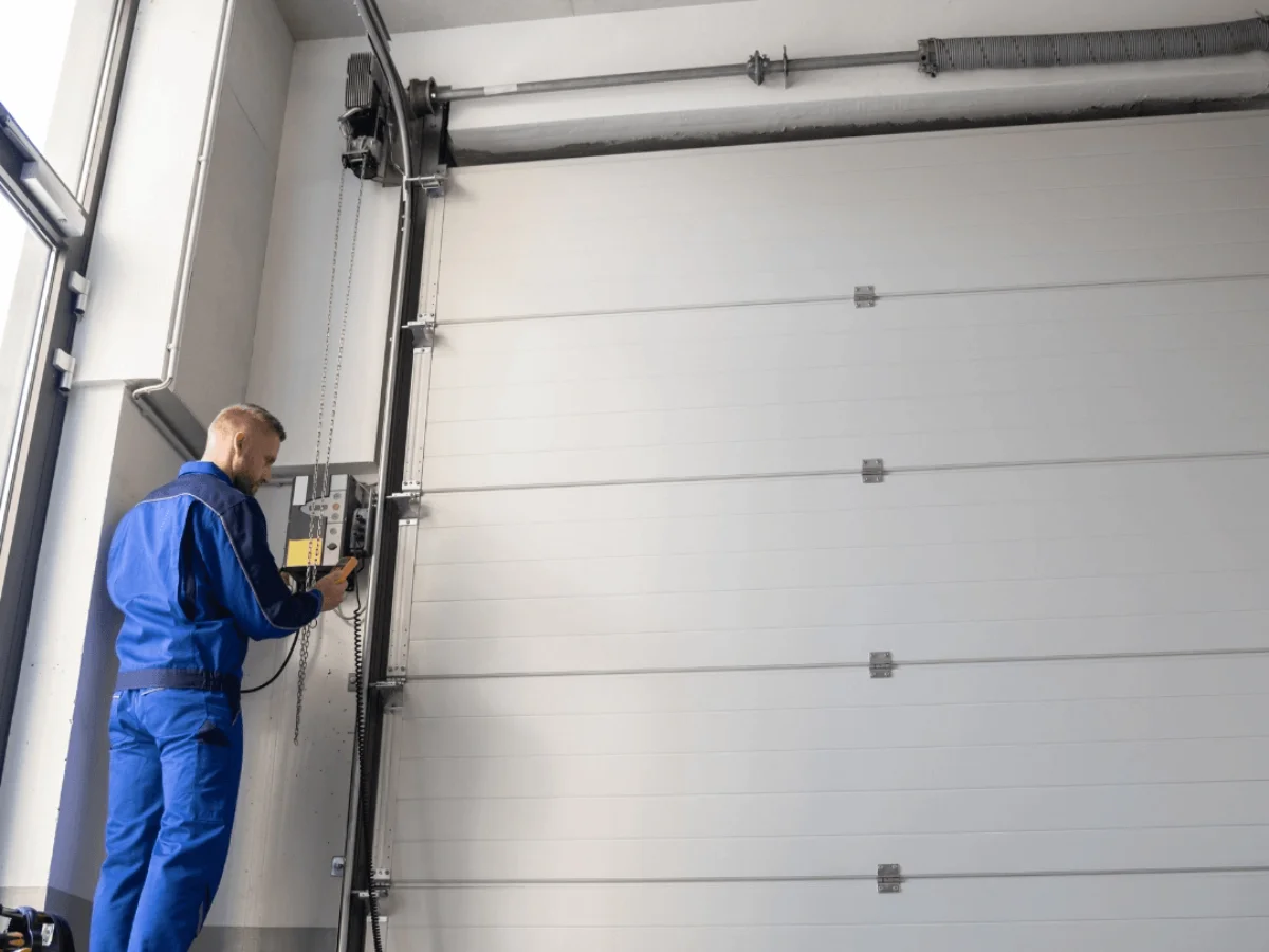 A man in a blue suit installing a garage door