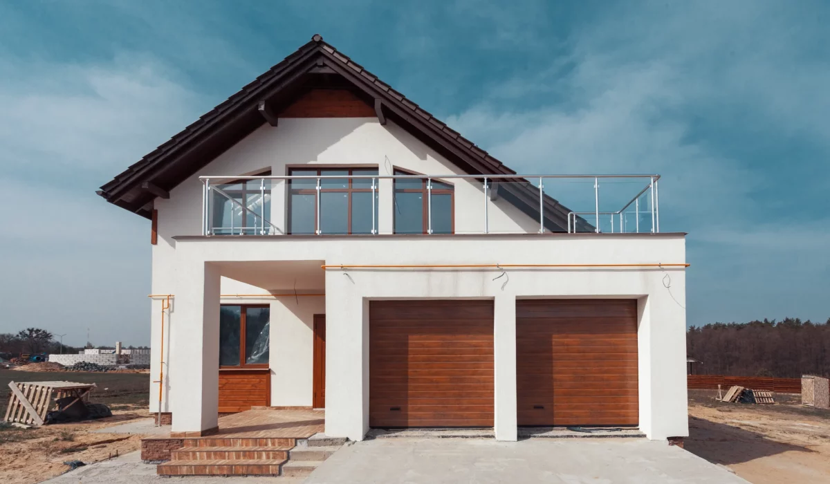 A white house with a brown door and a balcony